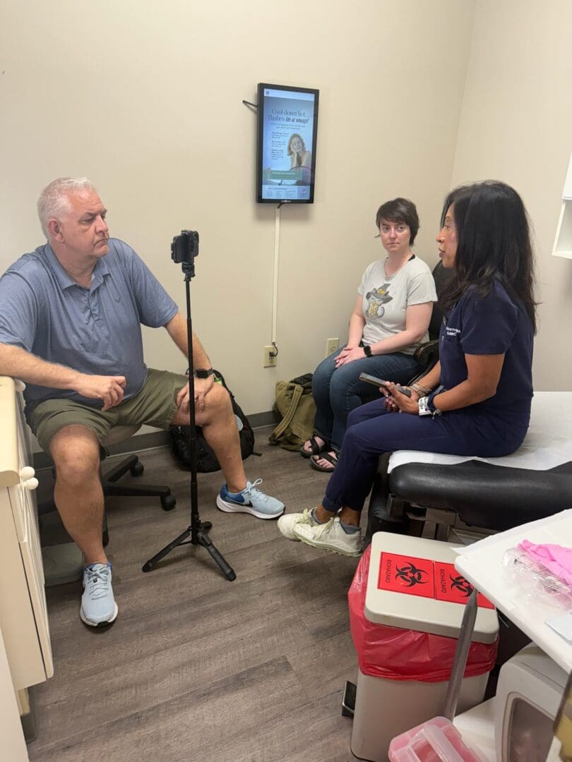 A man and two women having a conversation in a cozy room.